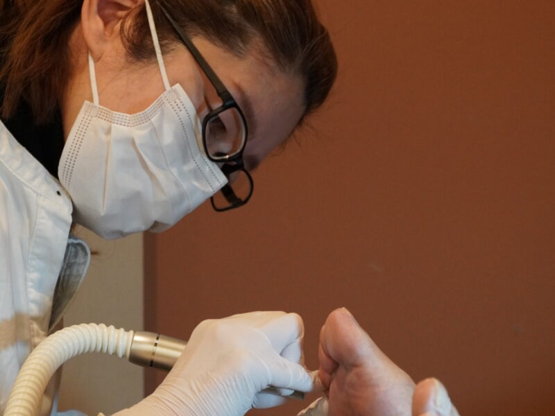 フットケア施術の様子。専門スタッフが足裏の角質ケアを行っている場面。